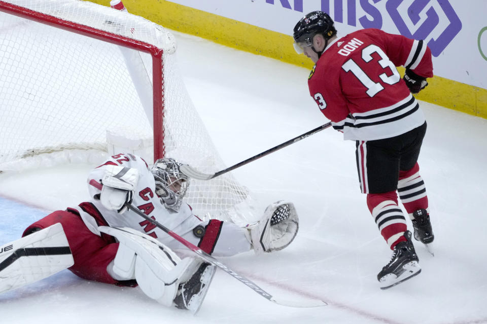 Carolina Hurricanes goaltender Pyotr Kochetkov, left, makes an arm-save on a shot by Chicago Blackhawks' Max Domi, right, during the second period of an NHL hockey game Monday, Nov. 14, 2022, in Chicago. (AP Photo/Charles Rex Arbogast)