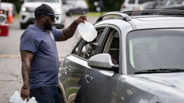 PHOTO: Workers with the Baltimore City Department of Public Works distribute jugs of water to city residents at the Landsdowne Branch of the Baltimore County Library on September 6, 2022 in Baltimore, Maryland.  (Drew Angerer/Getty Images)