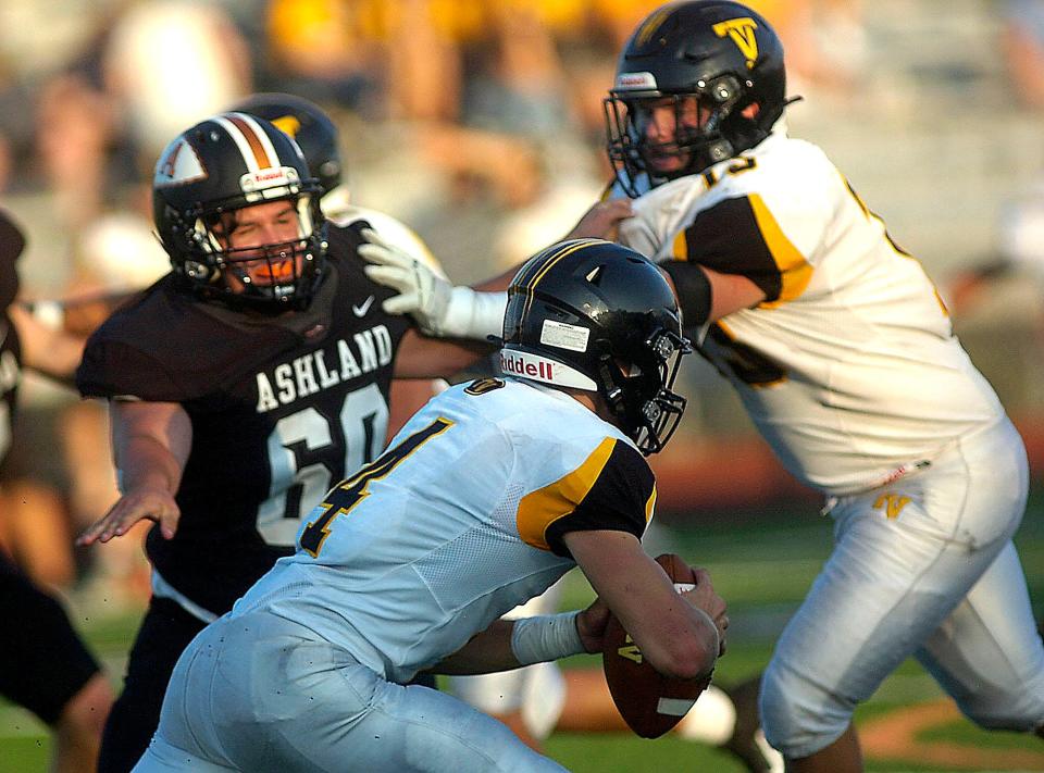 Ashland's Parker Grissinger forces Tri-Valley's Drew Burkhart out of the pocket during a game last season.