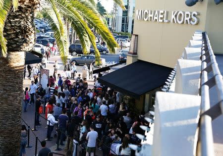 People wait in line to enter a Michael Kors store during day after Christmas sales at Citadel Outlets in Los Angeles, California in this file photo from December 26, 2014. REUTERS/Jonathan Alcorn/Files