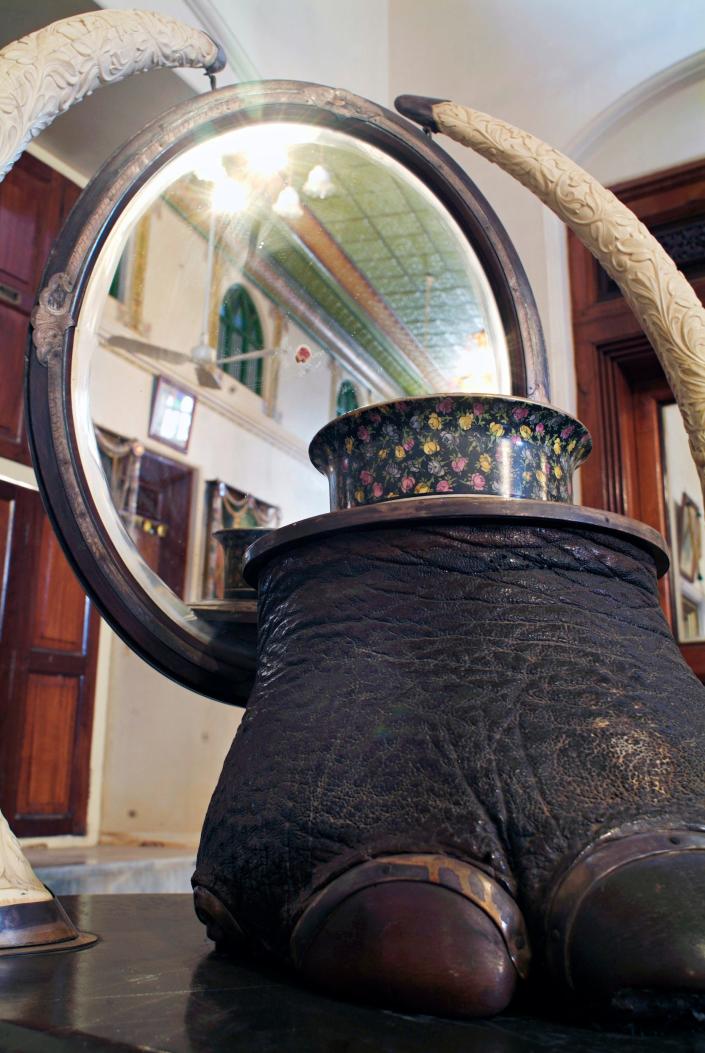 An elephant foot stool and tusks is in front of a mirror inside one of the Chettinad mansions in 2006.