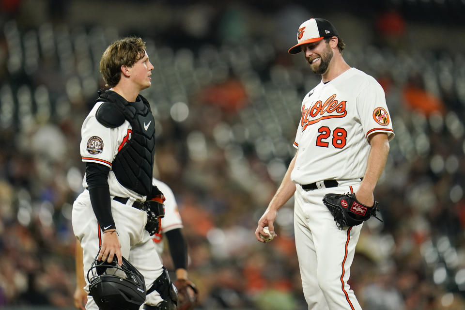 Baltimore Orioles starting pitcher Jordan Lyles (28) talks to catcher Adley Rutschman during the seventh inning of a baseball game against the Chicago White Sox, Thursday, Aug. 25, 2022, in Baltimore. (AP Photo/Julio Cortez)