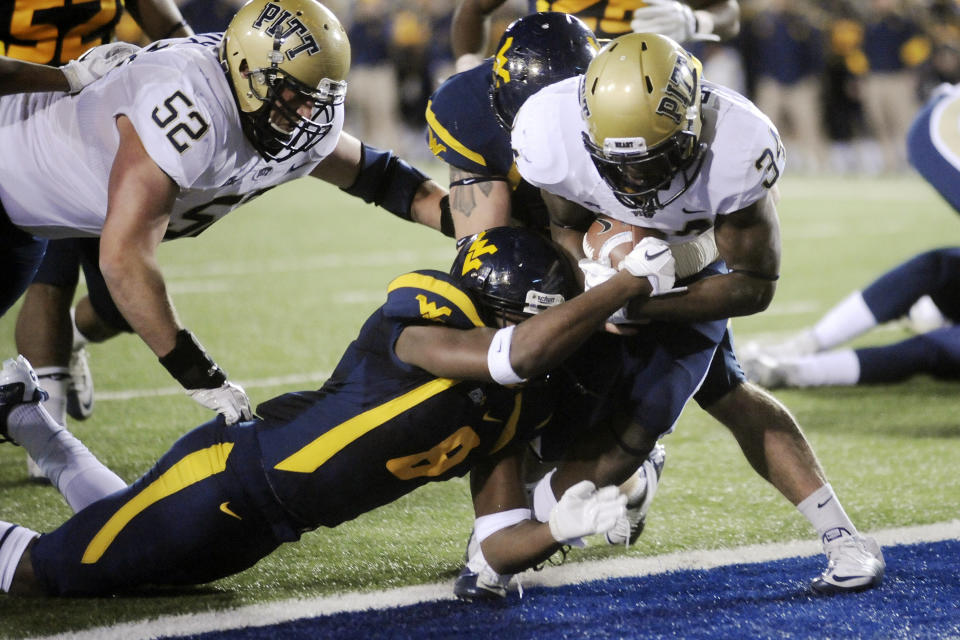 FILE - Pittsburgh's Issac Bennett leans into the end zone past West Virginia's Keith Tandy during the first quarter of an NCAA college football game Nov. 25, 2011, in Morgantown, W.Va. The rivalry between the longtime rivals will be renewed following an 11-year hiatus on Thursday, Sept. 1, 2022, when the 17th-ranked Panthers host the Mountaineers. (AP Photo/Jeff Gentner, File)