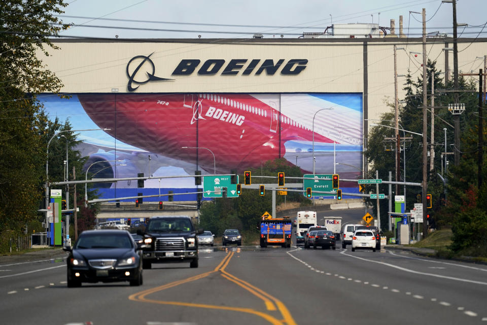 Traffic passes in view of a massive Boeing airplane production plant Thursday, Oct. 1, 2020, in Everett, Wash. Boeing said Thursday that it will consolidate production of its two-aisle 787 jetliner in South Carolina and shut down the original assembly line for the plane near Seattle. The company said the move will start in mid-2021. (AP Photo/Elaine Thompson)