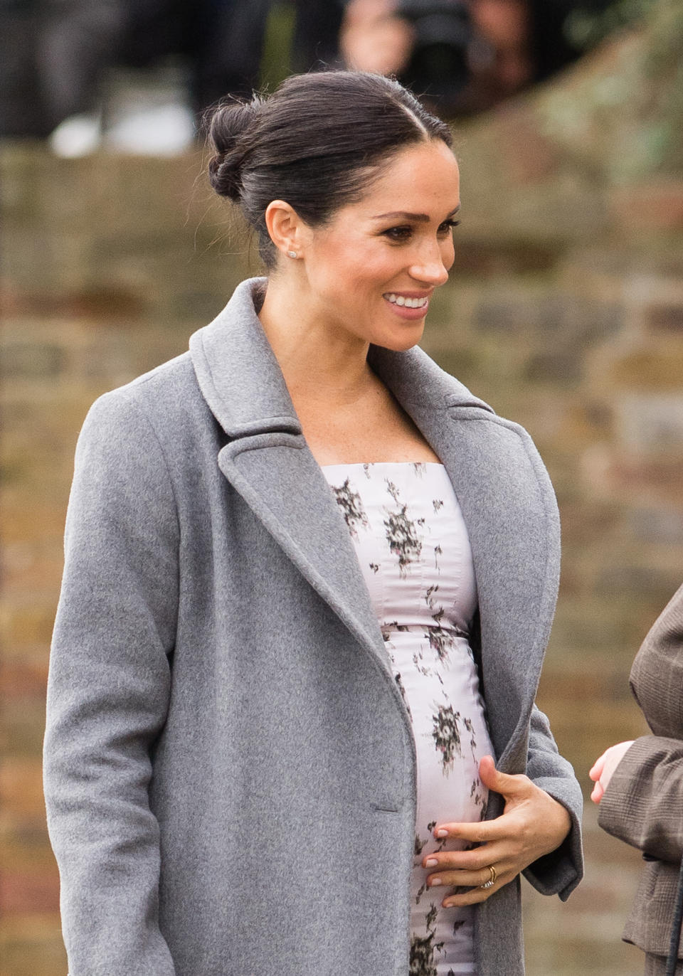 Meghan pats her baby bump [Photo: Getty]