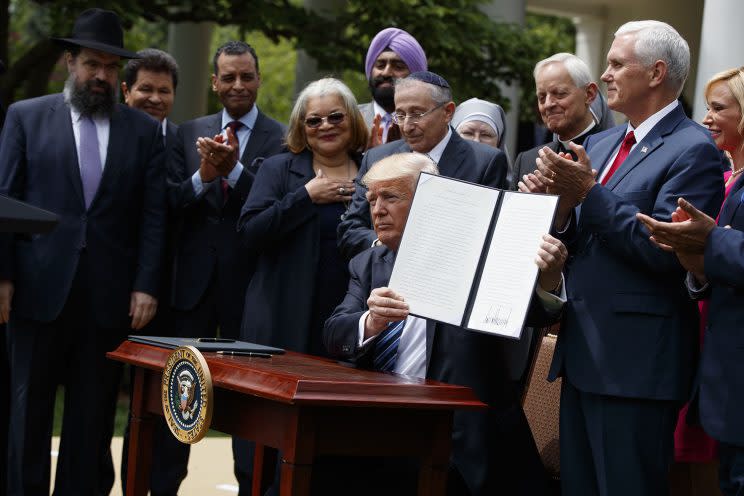 President Trump holds the executive order aimed at easing an IRS rule limiting political activity for churches, on May 4, 2017, in the White House Rose Garden.