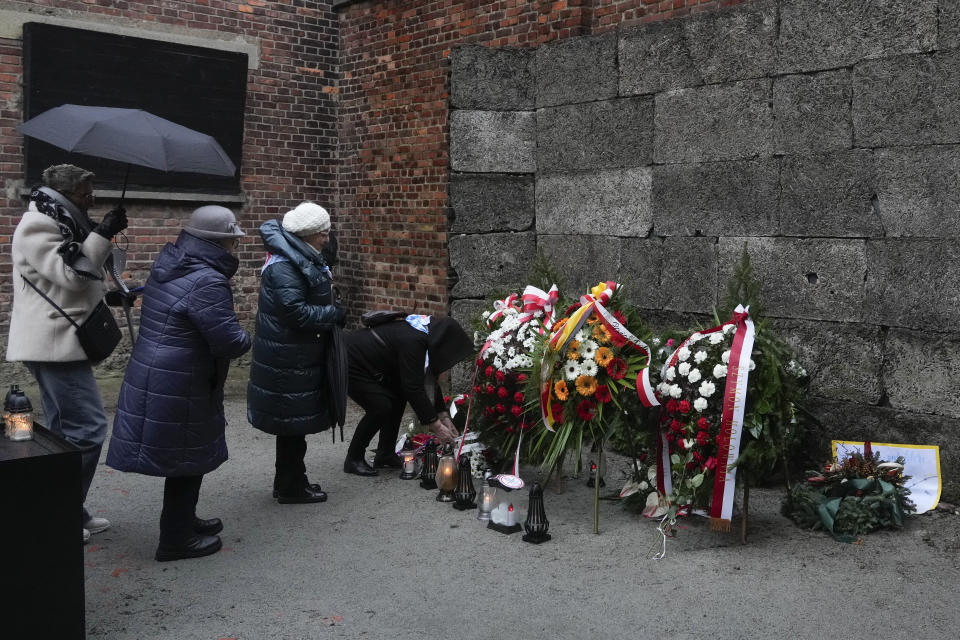 Holocaust survivors and relatives light candles at the Death Wall in the Auschwitz Nazi death camp in Oswiecim, Poland, Saturday, Jan. 27, 2024. Survivors of Nazi death camps marked the 79th anniversary of the liberation of the Auschwitz-Birkenau camp during World War II in a modest ceremony in southern Poland.(AP Photo/Czarek Sokolowski)