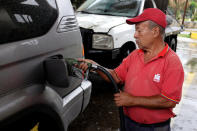 A gas station worker pumps gas into a car at a gas station of the Venezuelan state-owned oil company PDVSA in Caracas, Venezuela September 24, 2018. REUTERS/Marco Bello