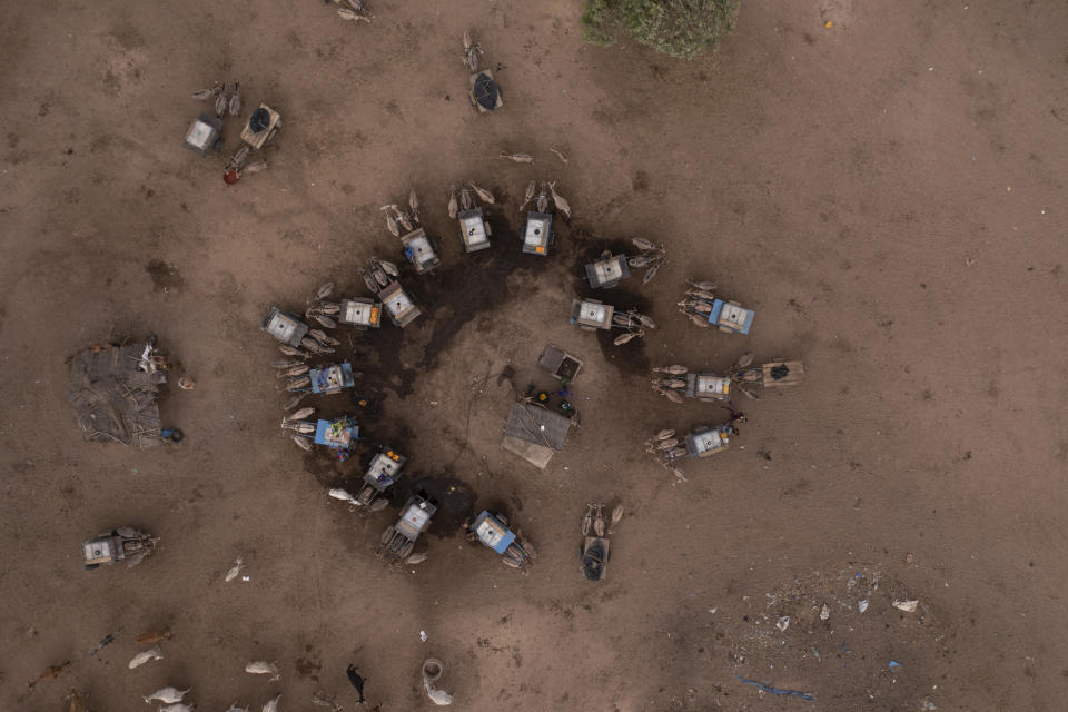 People with their donkey carts surround a borehole as they wait their turn to fill tanks with water at the village of Loumboul Dakaa, in the Matam region of Senegal, Wednesday, April 19, 2023. Conflicts between herders and settled farmers can erupt surrounding land use and access to water. (AP Photo/Leo Correa)