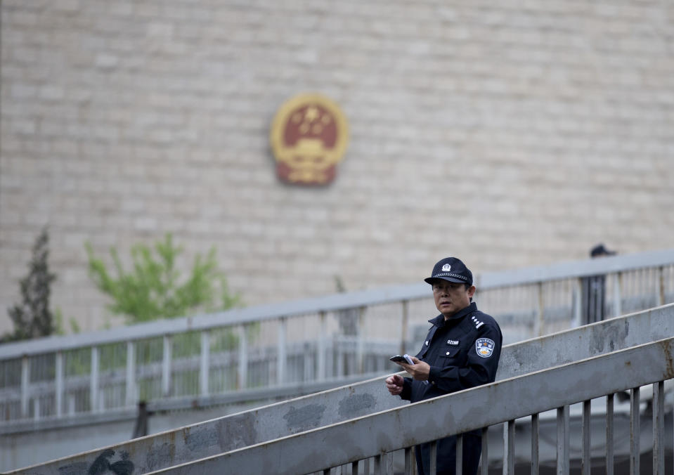 A Chinese policeman patrols on a pedestrian bridge near the Beijing Supreme People's High Court where Xu Zhiyong, the founder of a Chinese grassroots movement, attends his case in Beijing, China Friday, April 11, 2014. The Beijing high court on Friday upheld a guilty verdict against Xu that promoted clean governance. (AP Photo/Andy Wong)