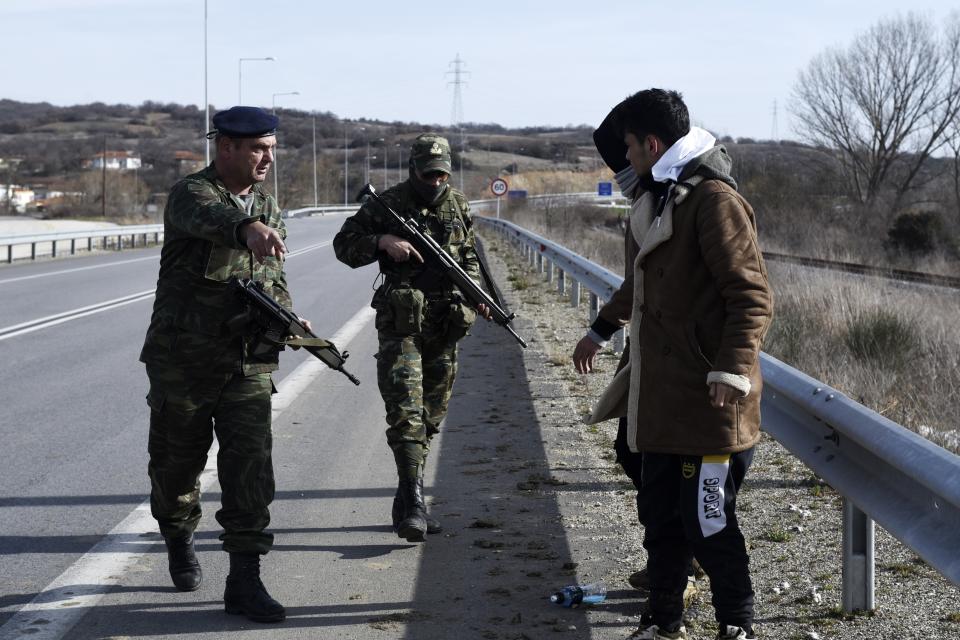 Greek Army detain migrants in the village of Mandra, Evros region, at the Greek-Turkish border on Tuesday, March 3, 2020. A child died when a boat full of migrants heading to a Greek island capsized Monday, part of a wave of thousands trying to push through Greece's land and sea borders. (AP Photo/Giannis Papanikos)