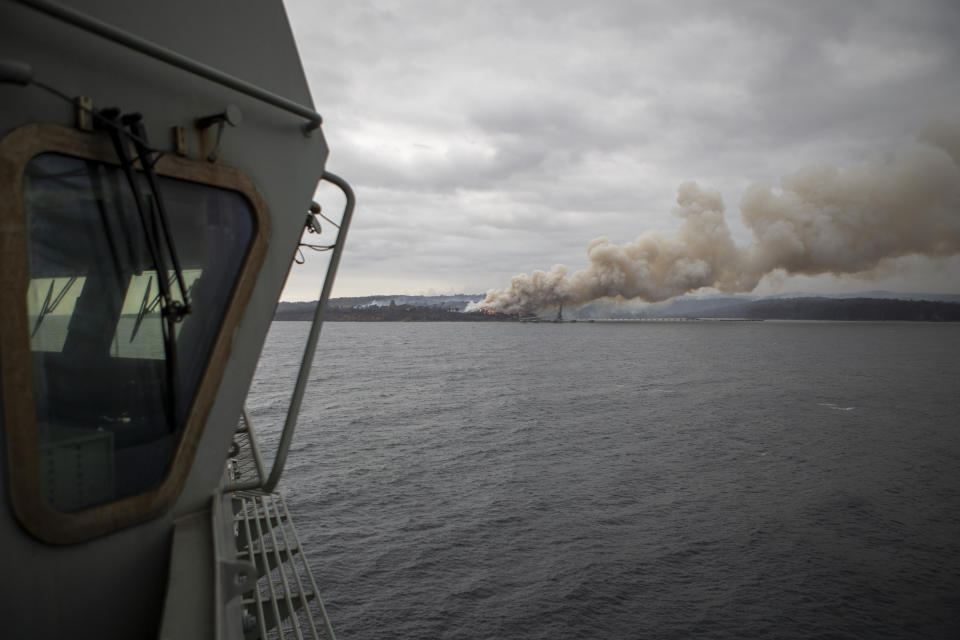 In this photo provided by the Australian Department of Defence on Jan. 6, 2020, a fire burns near Eden as HMAS Adelaide arrives to assist with wildfires. The wildfires have so far scorched an area twice the size of the U.S. state of Maryland. They have destroyed about 2,000 homes. (Able Seaman Thomas Sawtell/ADF via AP)