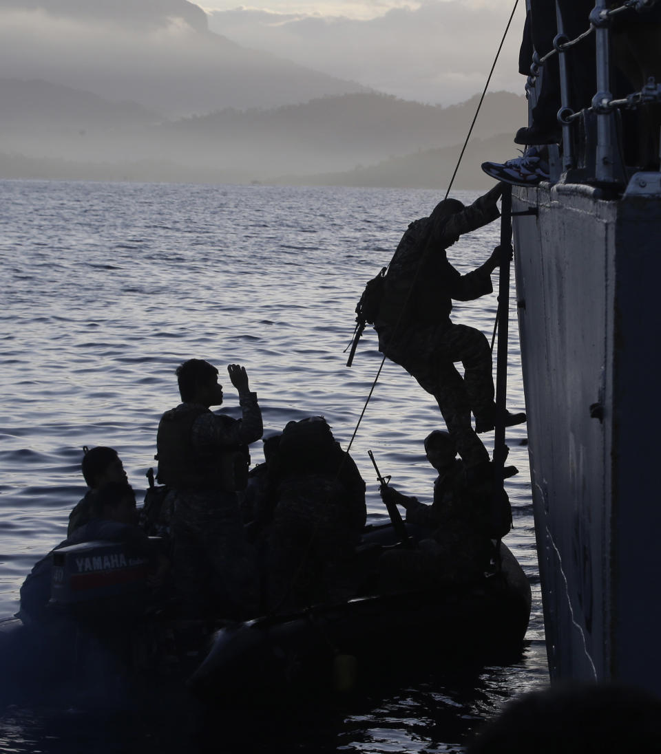 Philippine Marines disembark from a patrol ship following a mission Monday, March 31, 2014 in Palawan in southwestern Philippines. The Marines, who were deployed five months ago on board the dilapidated navy ship LT57 BRP Sierra Madre off the disputed Second Thomas Shoal, locally known as Ayungin Shoal, on the South China Sea, are awarded the Bronze Cross medal by Western Command Chief Lt.Gen. Roy Deveraturda upon arrival at a naval base Monday. (AP Photo/Bullit Marquez)