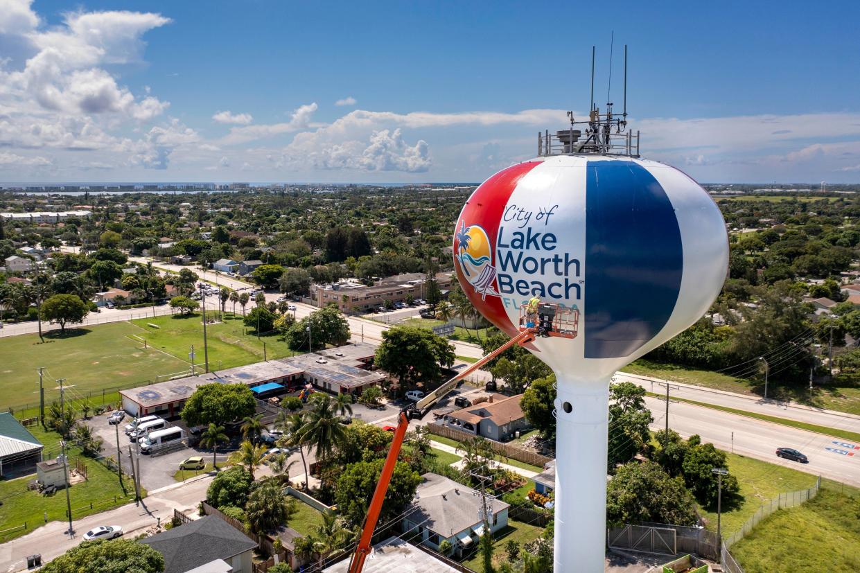 Jimmy Kelly paints the last letters on the side of the water tower in Lake Worth Beach, Florida on August 4, 2023. The tower was last painted in 2012 to honor the city's centennial.