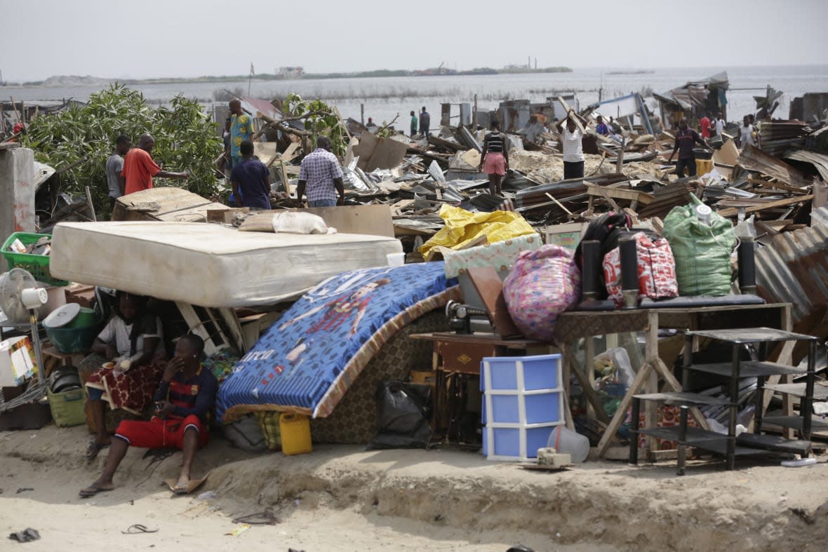 FILE- Residents salvage objects from houses demolished by government officials in Otodo-Gbame waterfront in Lagos Nigeria. Saturday, March 18, 2017. Slums and shantytowns are often targeted in rampant demolitions across Africa’s most populous country, and especially in Abuja. The government has defended the actions as a sustained effort to restore the city’s master plan, a conceptual layout meant to promote growth in this oil-rich Western African nation. (AP Photo/Sunday Alamba, File)