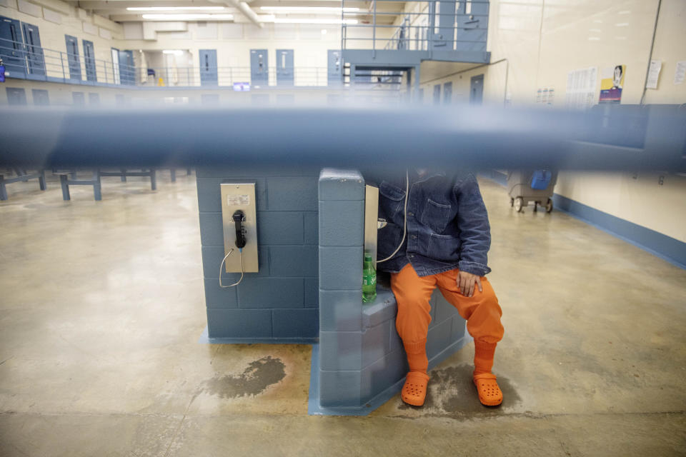 A detainee talks on the phone in his pod at the Stewart Detention Center, Friday, Nov. 15, 2019, in Lumpkin, Ga. It's difficult for detained immigrants to see or even speak to lawyers who live far away, and they have no access to email or fax and the phones sometimes don't work or are expensive, according to the Southern Poverty Law Center attorney Erin Argueta, one of three attorney's who work full time in Lumpkin. Communications have to be sent by mail, which slows the process of collecting documentation, filling out forms in English and getting documents translated and notarized. (AP Photo/David Goldman)