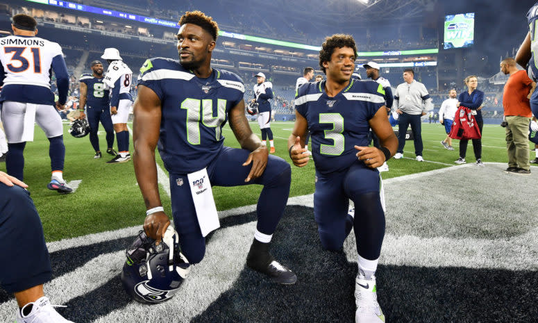 D.K. Metcalf #14 and Russell Wilson #3 of the Seattle Seahawks take a knee