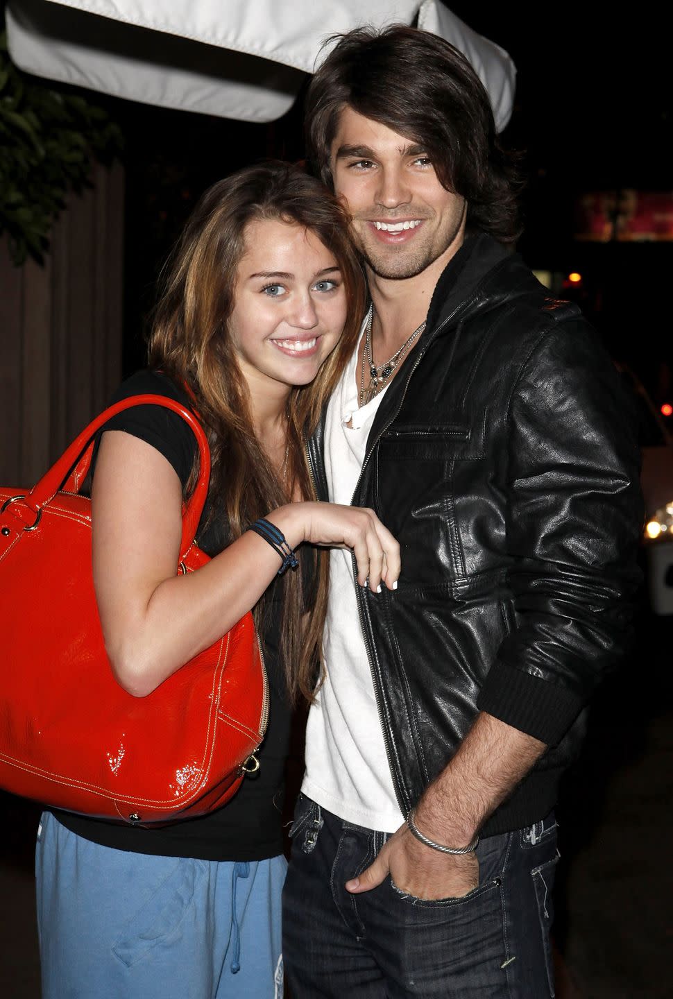 los angeles, ca march 9 singer miley cyrus l and model justin gaston visit nubu march 9, 2009 in west hollywood, california photo by jean baptiste lacroixwireimage