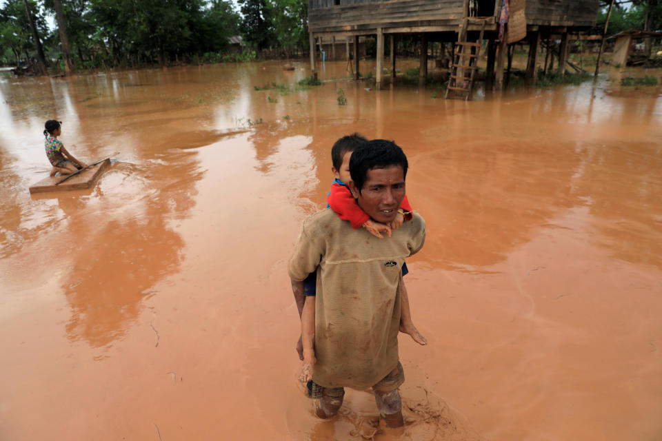 <p>A man carries his child during the flood after the Xepian-Xe Nam Noy hydropower dam collapsed in Attapeu province, Laos, July 26, 2018. (Photo: Soe Zeya Tun/Reuters) </p>