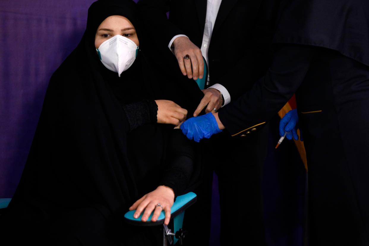 Tayebeh Mokhber is injected with the Coviran coronavirus vaccine produced by Shifa Pharmed, part of a state-owned pharmaceutical conglomerate, in a ceremony in Tehran, Iran on Tuesday, Dec. 29, 2020. The first study of the safety and effectiveness of the coronavirus vaccine in Iran began Tuesday, state TV reported, with dozens due to receive the domestically-developed shot in the hardest-hit country in the Middle East.