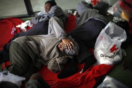 An African woman immigrant rests inside a sports center after arriving on a rescue ship at the southern Spanish port of Tarifa, near Cadiz, southern Spain August 12, 2014. REUTERS/Jon Nazca