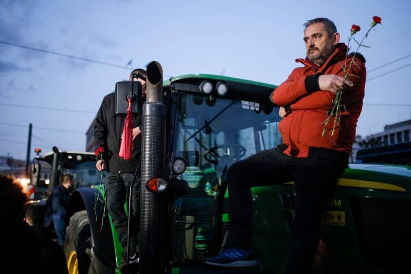Farmers stand on their tractors in front of the Greek parliament during a demonstration in the center of Athens. Socrates Baltagiannis/dpa