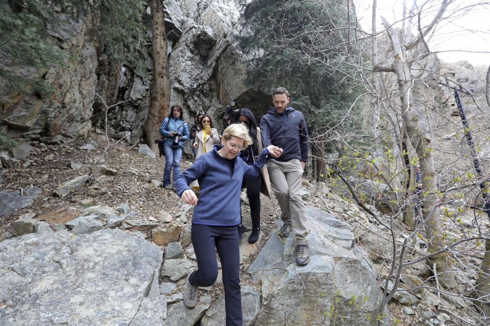 Democratic presidential candidate Sen. Elizabeth Warren, D-Mass., walks with Carl Fisher, of Save Our Canyons, during an visit to Big Cottonwood Canyon Wednesday, April 17, 2019, east of Salt Lake City. Warren is in Utah Wednesday after promising to restore broader public lands protections for two of the state's high-profile national monuments if elected president. It's a move that would not endear her to Utah's GOP establishment but could appeal to voters across the West angered by President Donald Trump's decision to shrink the monuments. (AP Photo/Rick Bowmer)