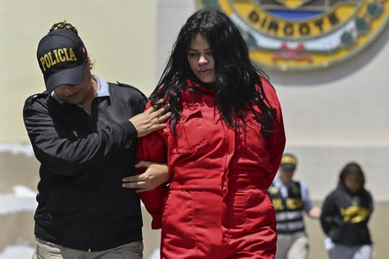 Una agente de la policía peruana traslada a una integrante de la banda criminal Tren de Aragua el 5 de octubre de 2023 en Lima (Cris Bouroncle)