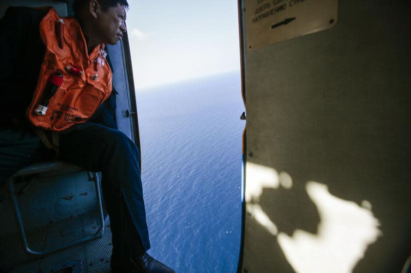 A military personnel looks out of a helicopter during a search and rescue mission off Vietnam's Tho Chu island March 10, 2014. — Reuters pic