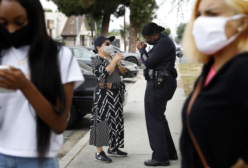 LOS ANGELES-CA-JULY 23, 2020: Emada Tingirides, center right, chats with Augie Lopez with the Housing Authority of the City of Los Angeles , left, during a visit to Nickerson Gardens in Watts on Thursday, July 23, 2020. A community policing program known as Community Safety Partnership will now have its own bureau within the LAPD, headed by Emada Tingirides, whom will become the LAPD's second Black female deputy chief. (Christina House / Los Angeles Times)