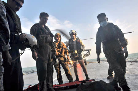 U.S. Navy personnel prepare to carry a body onto U.S. Navy helicopter from USS America during a search and rescue operation for survivors of the USS John S. McCain ship collision in Malaysian waters in this handout photo distributed August 23, 2017. Royal Malaysian Navy Handout via REUTERS