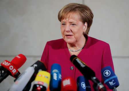 Leader of the Christian Democratic Union (CDU) and the acting German Chancellor Angela Merkel delivers a speech before exploratory talks about forming a new coalition government at the SPD headquarters in Berlin, Germany, January 7, 2018. REUTERS/Hannibal Hanschke