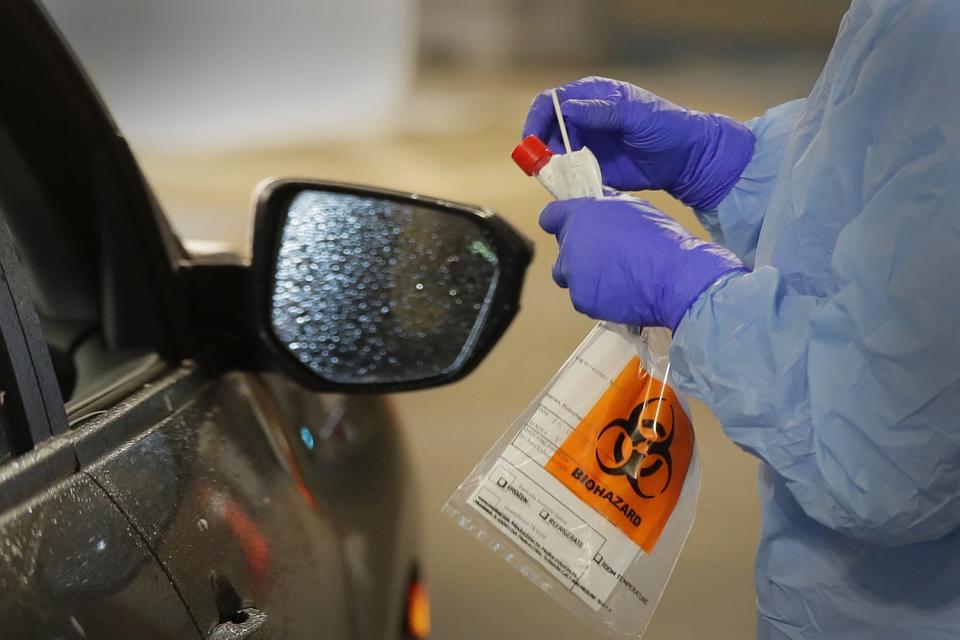 WASHINGTON: A nurse at a drive-up coronavirus testing station in Seattle holds a swab used to take a sample from the nose of a person in their car on March 13.