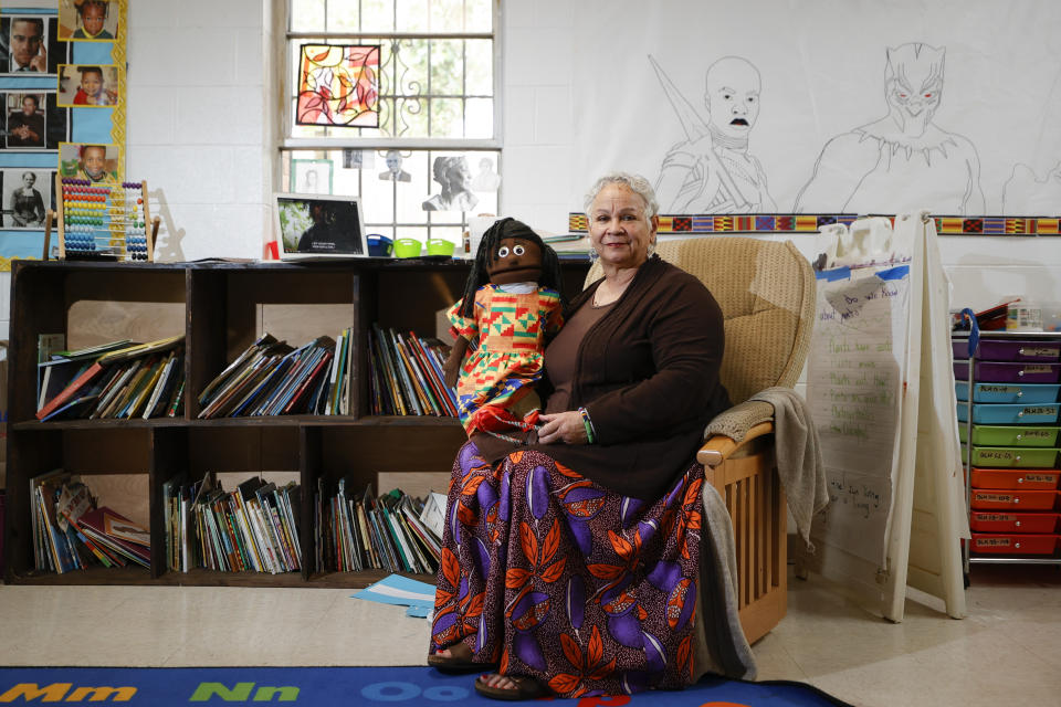 Aminata Umoja, of, Lithonia, Ga., poses for a portrait with a puppet named Swahili in a classroom at the Kilombo Academic and Cultural Institute, Tuesday, March 28, 2023, in Decatur, Ga. Umoja is an educator and the founder of the Kilombo Academic and Cultural Institute. (AP Photo/Alex Slitz)