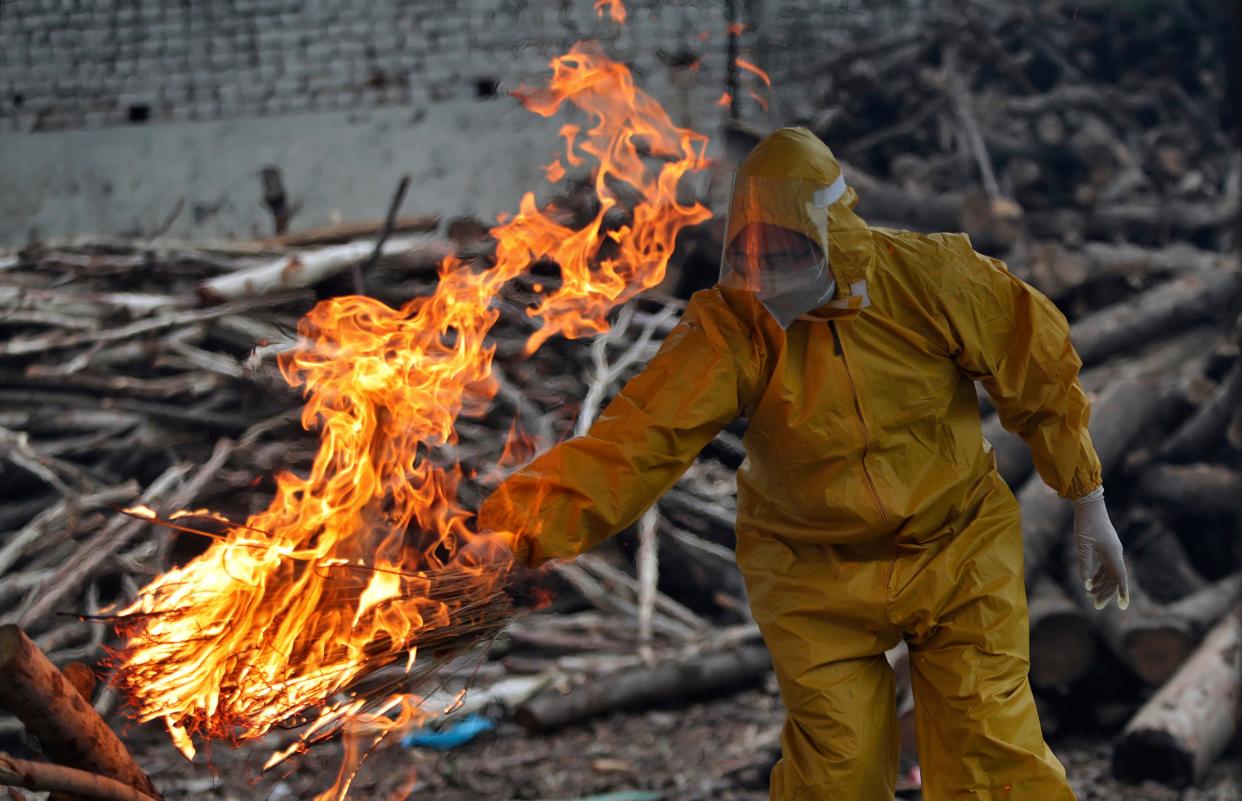 A family member of a person who died of Covid-19 lights the funeral pyre at a crematorium in Jammu (AP)