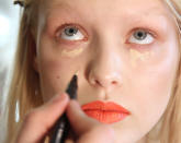 <b>Behind-the-scenes at Oscar de la Renta's AW13 New York Fashion Week show</b><br><br>Under-eye highlighter is applied to a model backstage, with her coral pout being the focus.<br><br>©Rex<br><br>