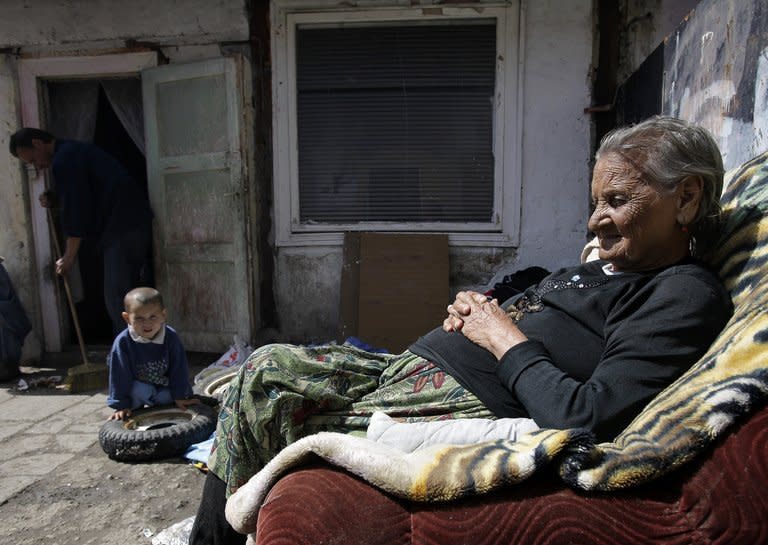 An elderly woman and her grandson sits outside their home in Miskolc, Hungary on April 22, 2012. The National Food Bank says that without its help 210,000 families in Hungary would struggle to put food on the table, a 30% increase from last year