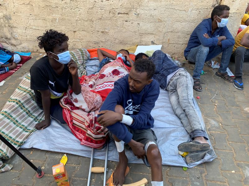 Migrants wait outside the United Nations High Commissioner for Refugees (UNHCR) negotiation office in Tripoli