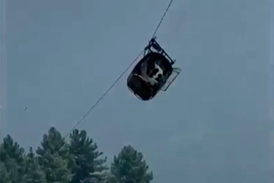 A cable car carrying eight people dangles hundreds of meters above the ground in the remote Battagram district, Khyber Pakhtunkhwa, Pakistan on Tuesday.