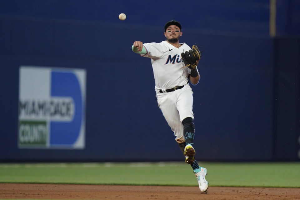 Miami Marlins shortstop Miguel Rojas throws to first to put out Colorado Rockies' Yonathan Daza during the third inning of a baseball game, Thursday, June 23, 2022, in Miami. (AP Photo/Wilfredo Lee)