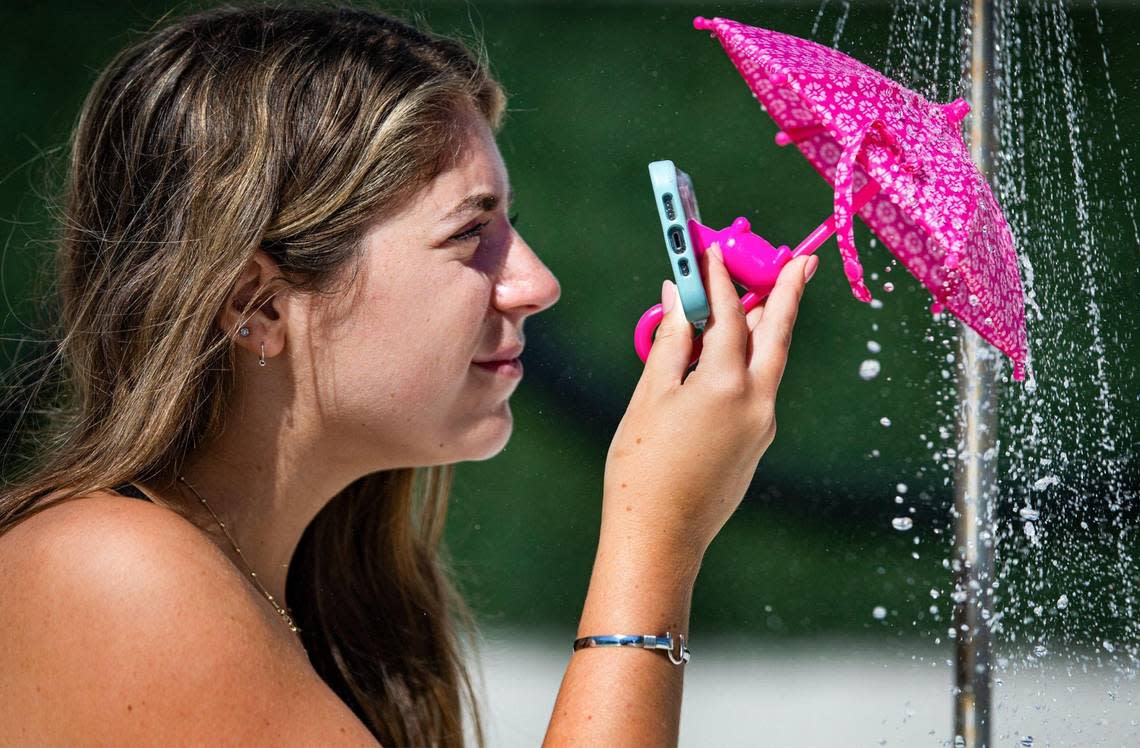 Miami Herald photographer Alie Skowronski demonstrates the cell phone umbrella for the Dave Barry 2022 Holiday Gift Guide in Miami, Florida, on Wednesday, Nov. 16, 2022.