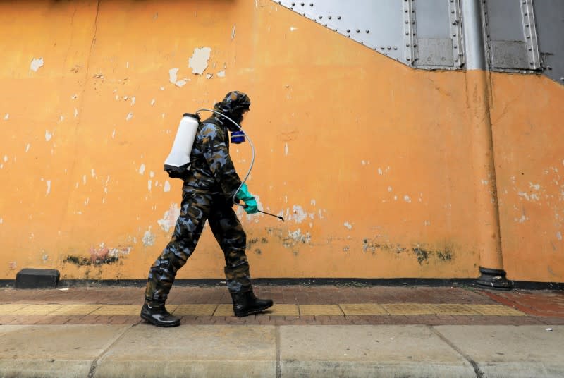 FILE PHOTO: An airforce member sprays disinfectant inside a main railway station, as the number of people tested positive for coronavirus disease in the country increased, in Colombo