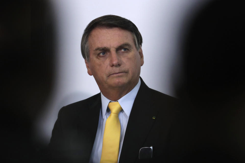 Brazil's President Jair Bolsonaro listens during a presentation at the Planalto Presidential Palace in Brasilia, Brazil, Monday, Oct. 19, 2020. The Brazilian government announced the results of clinical tests with use of the drug Nitazoxanide for COVID-19 treatment. (AP Photo/Eraldo Peres)