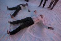 People make snow angels during a snow storm in Times Square in the Manhattan borough of New York, January 23, 2016. REUTERS/Carlo Allegri