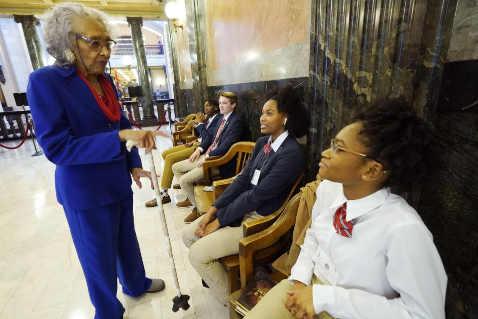 CORRECTS ELECTION YEAR TO 1985, NOT 1984 - State Rep. Alyce Clarke, D-Jackson, speaks to House pages Trinity Golden, right, Eryn McDaniel, second from right, Van Ross, center, and Corey Wiggins, outside the body's chamber at the Mississippi Legislature, Tuesday, Jan. 31, 2023, in Jackson, Miss. Clarke, who was first elected to the House in 1985, announced Tuesday that she will not seek reelection. (AP Photo/Rogelio V. Solis)