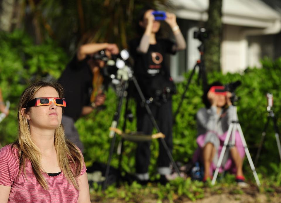 PALM COVE, AUSTRALIA - NOVEMBER 14: A spectator views the solar eclipse through special eclipse viewing glasses on November 14, 2012 in Palm Cove, Australia. Thousands of eclipse-watchers have gathered in part of North Queensland to enjoy the solar eclipse, the first in Australia in a decade. (Photo by Ian Hitchcock/Getty Images)