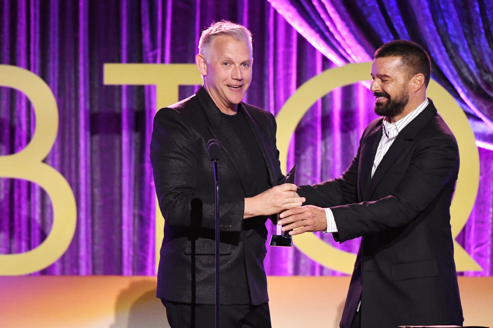 Abe Sylvia and Ricky Martin appear on stage at the LGBTQ+ awards show