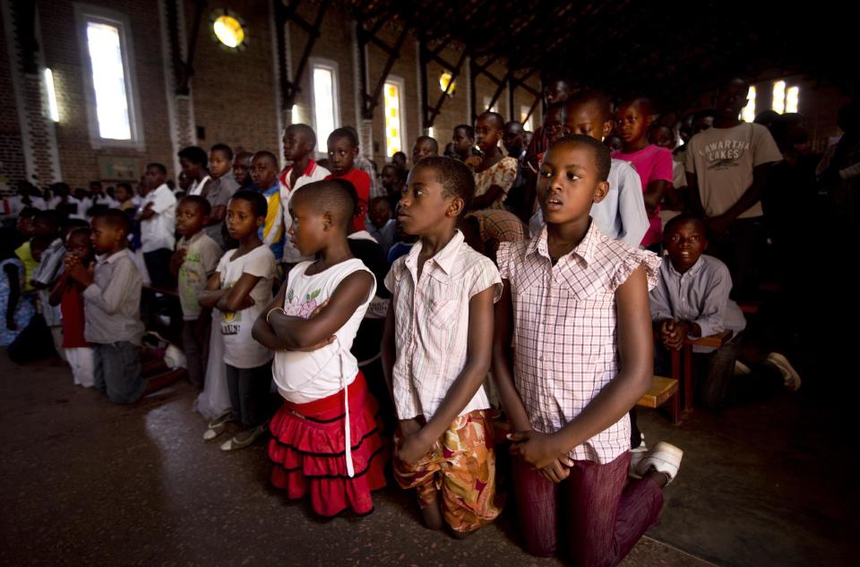 Rwandan children listen and pray during a Sunday morning service at the Saint-Famille Catholic church, the scene of many killings during the 1994 genocide, in the capital Kigali, Rwanda Sunday, April 6, 2014. Rwanda will commemorate on Monday the 20-year anniversary of the genocide when ethnic Hutu extremists killed neighbors, friends and family during a three-month rampage of violence aimed at ethnic Tutsis and some moderate Hutus, leaving a death toll that Rwanda puts at 1,000,050. (AP Photo/Ben Curtis)