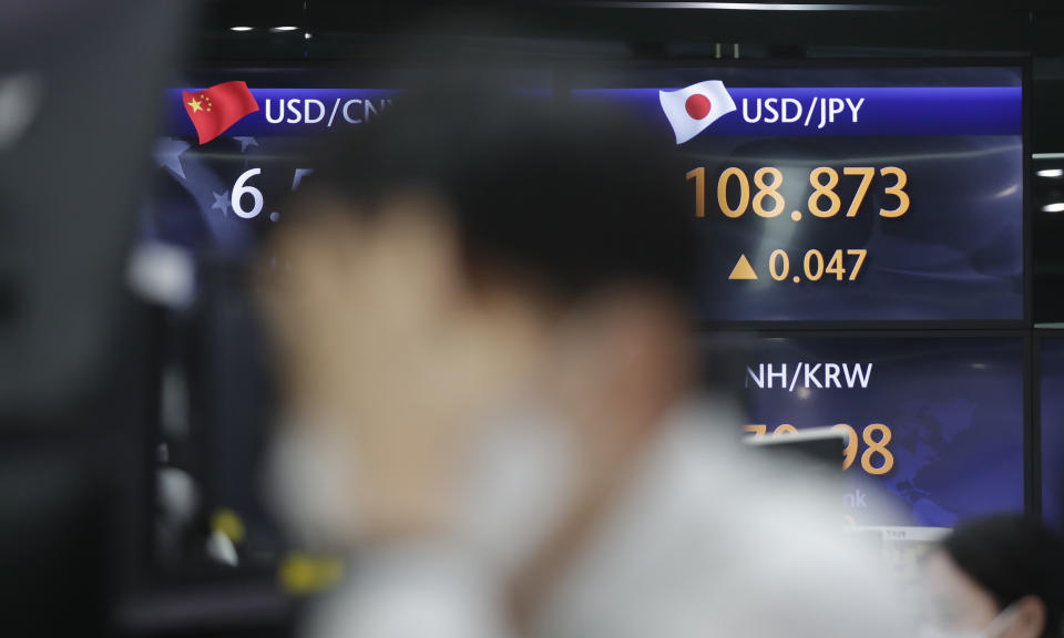 A currency trader watches computer monitors near the screens showing the foreign exchange rates at the foreign exchange dealing room in Seoul, South Korea, Thursday, April 15, 2021. Asian stock markets were mixed Thursday after Wall Street retreated from a record high as major banks reported strong profits at the start of U.S. earnings season. (AP Photo/Lee Jin-man)