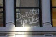 A sign is seen in a window at the WeWork corporate headquarters in Manhattan, New York